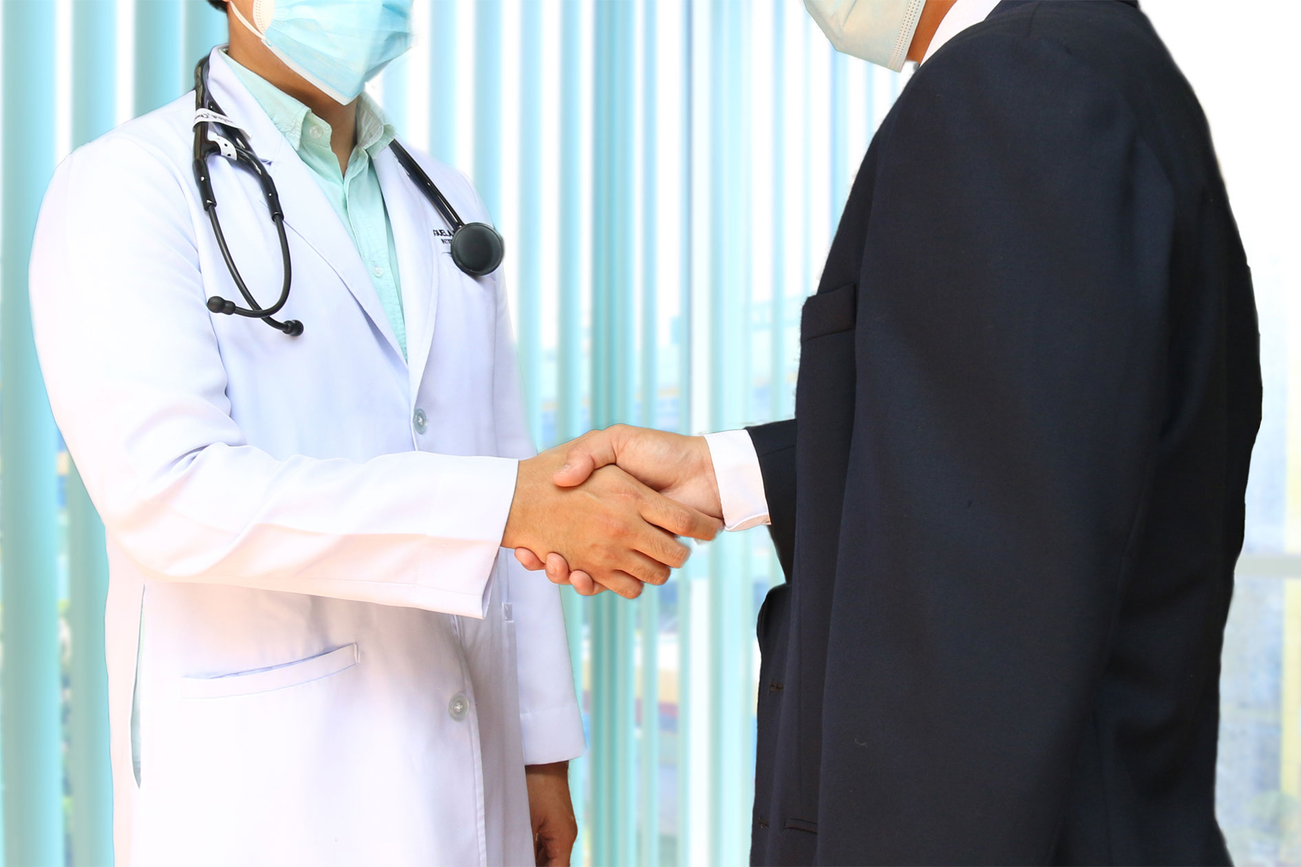 Administrative leader in a suit shakes hands with a clinician.
