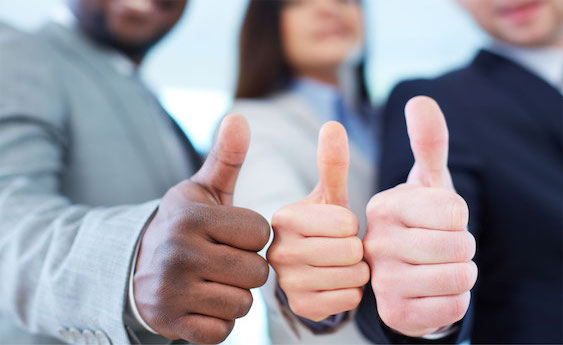 Person in a suit giving a thumbs-up to demonstrate approval