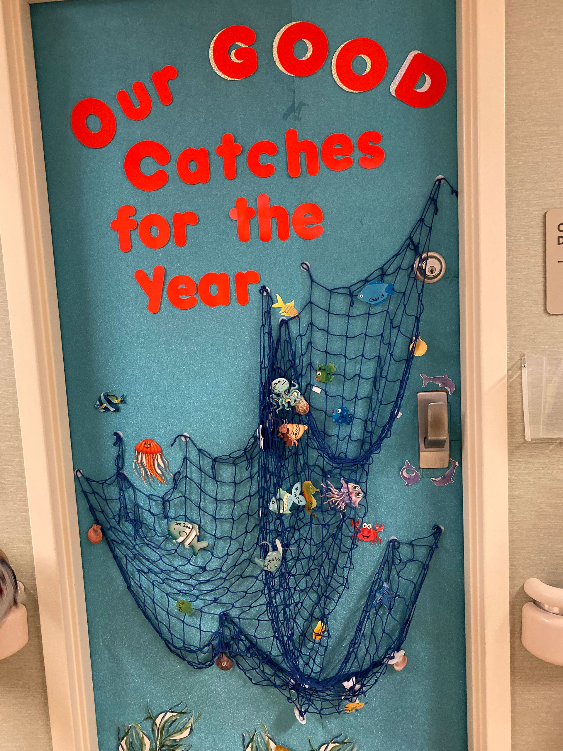 Doorway decorated with fish netting and paper fish saying our good catches of the year.