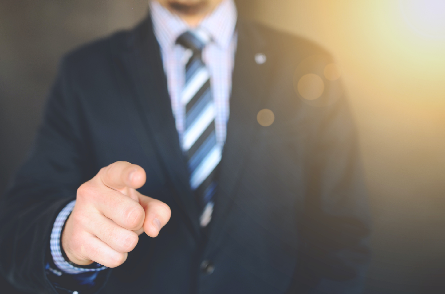 A man in professional attire pointing at something